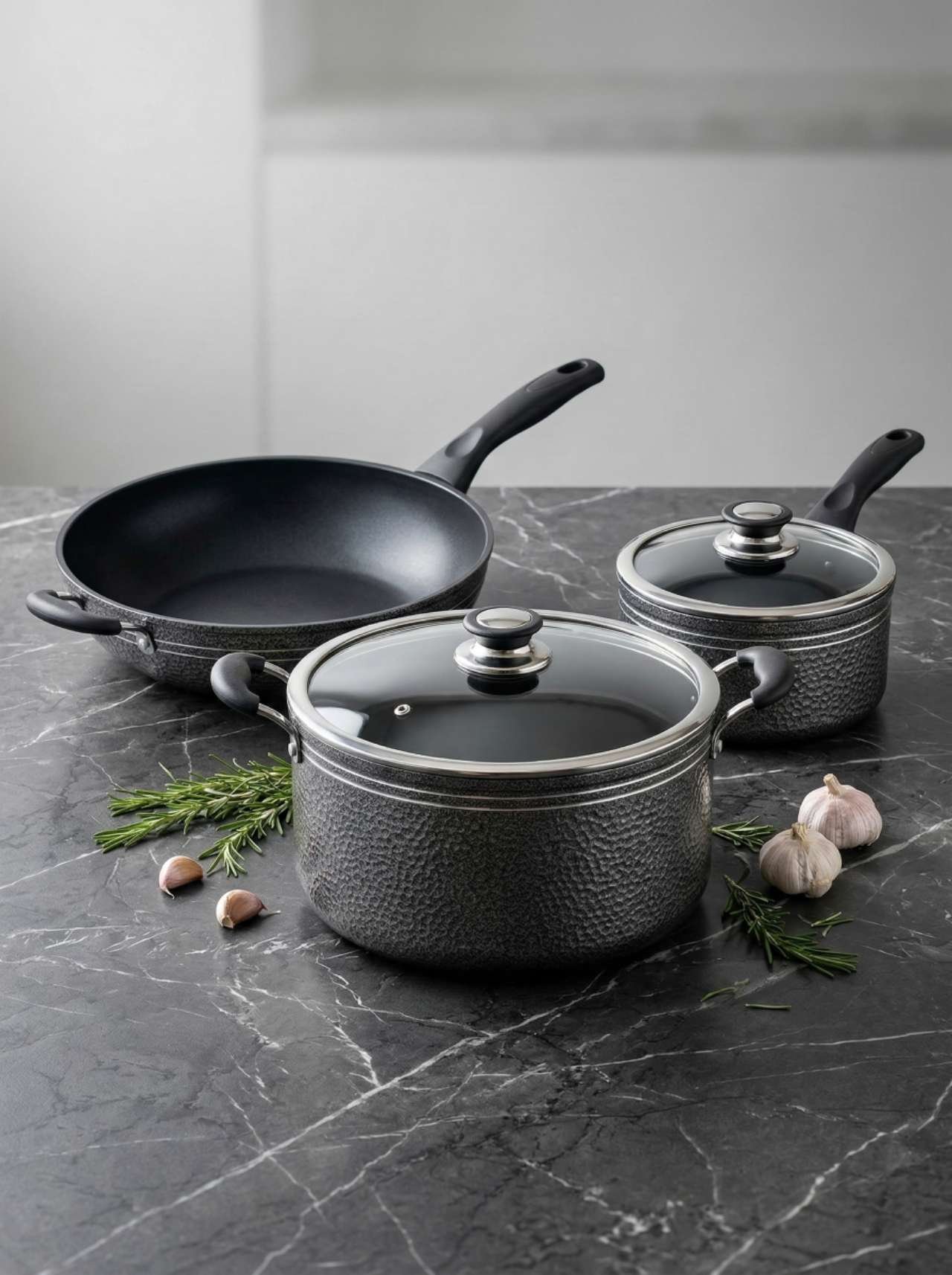 LIETTA black cookware set styled on a stone countertop